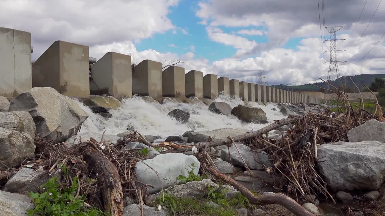 바위 위로 물이 떨어지는 인공 댐의 왼쪽에서 오른쪽으로 느린 팬
