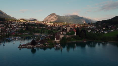 descripción aérea que orbita alrededor del castillo medieval, schloss spiez en la orilla del lago thun