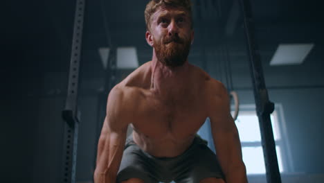 Young-man-doing-the-clean-and-jerk-weightlifting-exercise-at-the-gym.-Man-doing-deadlift-exercise-at-gym.-Young-athlete-lifts-barbell-to-his-chest.-Male-weightlifter-lifting-a-barbell-at-a-competition