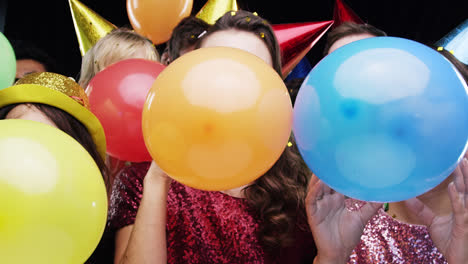 multi racial group of friends blowing balloons slow motion party photo booth