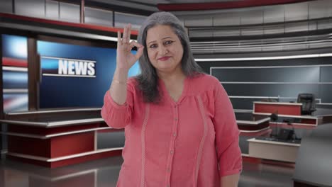 feliz periodista india senior mostrando el signo de está bien