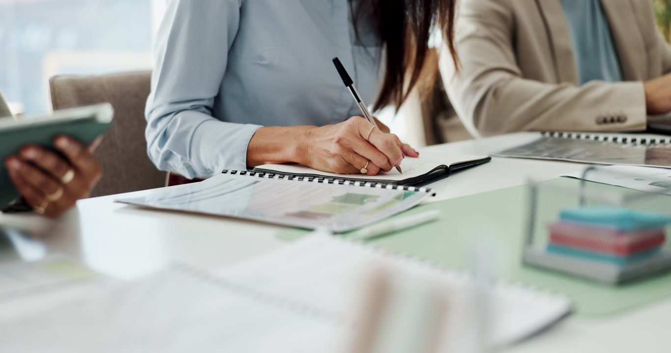 Businesswoman Writing Notes in a Meeting at the Office