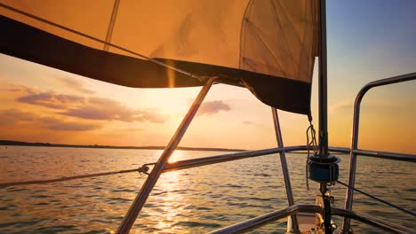 The-front-bow-of-a-white-sailing-boat-with-sunset-and-sea-background