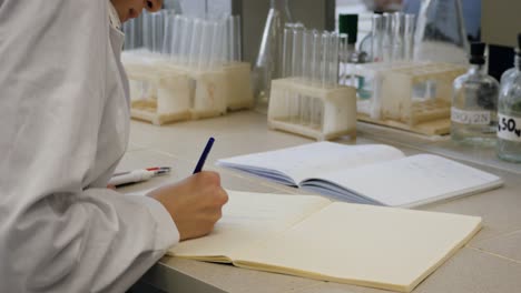 scientist writing in a lab notebook