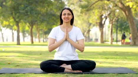 Chica-India-De-Yoga-Haciendo-Pose-De-Yoga-Namaste-En-Un-Parque-Por-La-Mañana