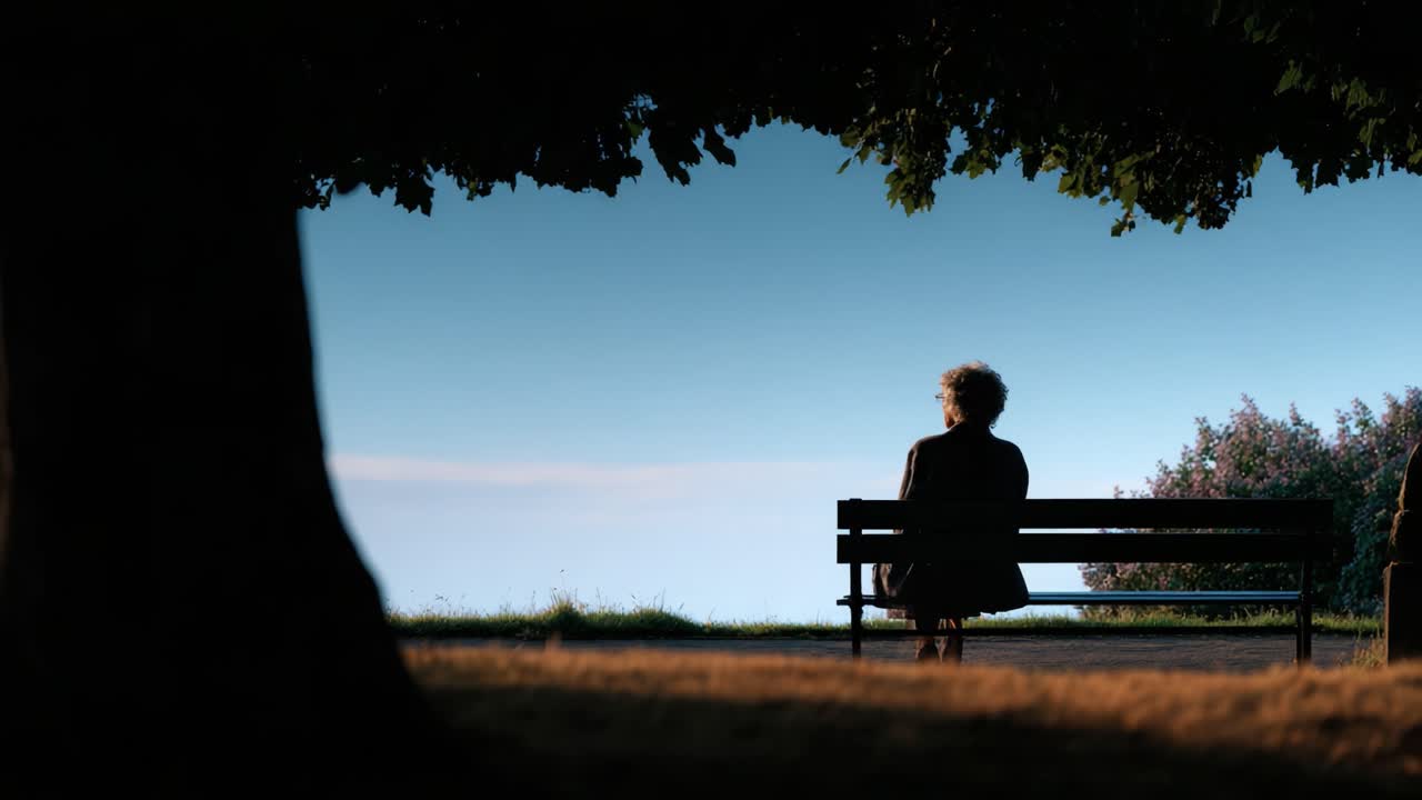 A solitary figure sits quietly on a bench under a leafy tree, gazing thoughtfully into the distance, blending tranquility and introspection in serene nature