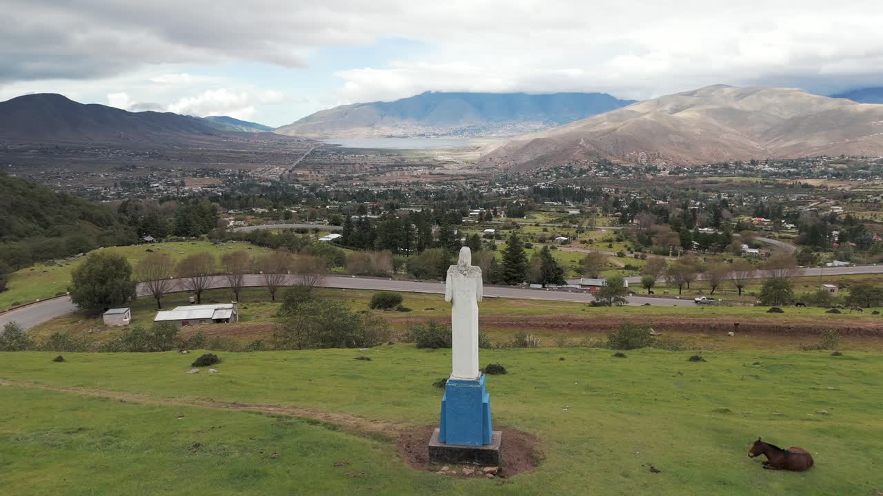 'El Cristo' of Tafí del Valle viewed from behind by a drone, with the beautiful valley and La Angostura Dam in the background