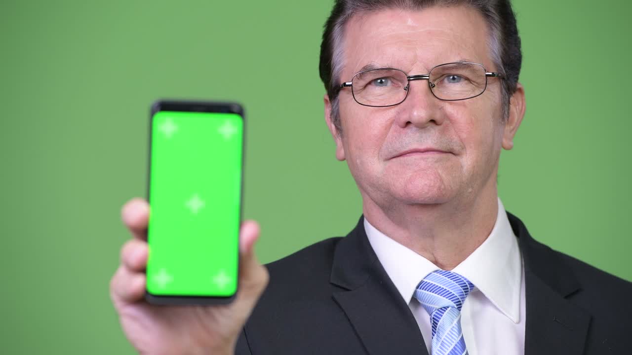 Senior handsome businessman showing phone