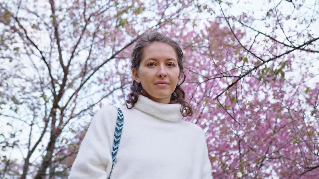 Woman in a park under cherry blossom trees