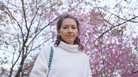 woman in a park under cherry blossom trees
