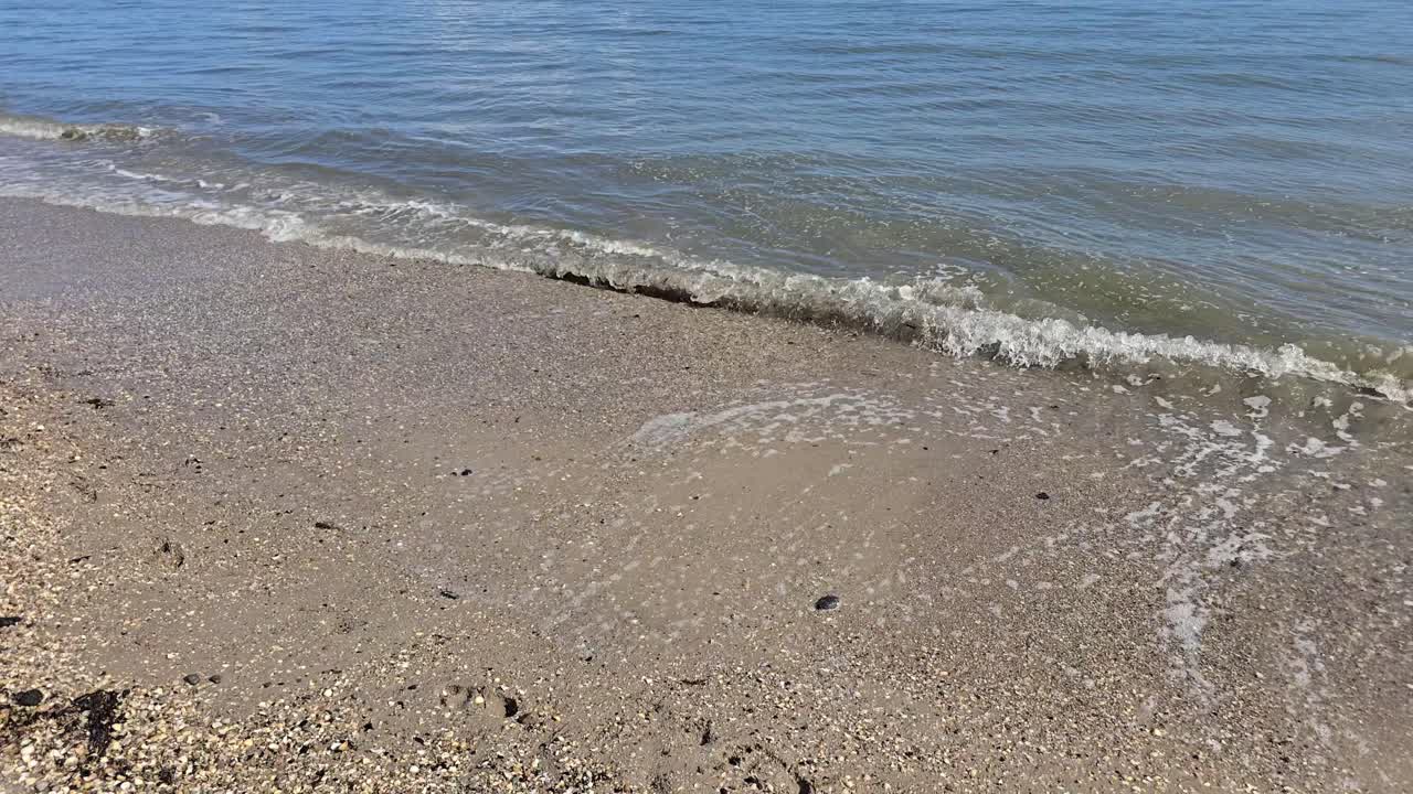 Slow motion soft sea waves rolling on golden sandy beach