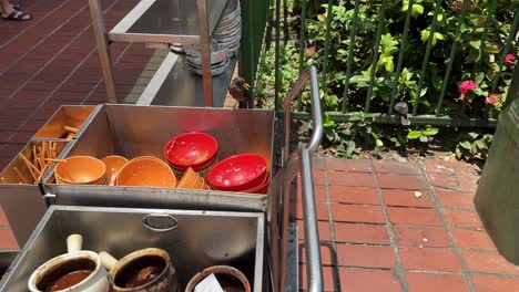 Scene-of-a-Javan-Mynah-bird-looking-at-the-pile-of-uncleared-dirty-bowls-outside-coffeeshop-in-Singapore