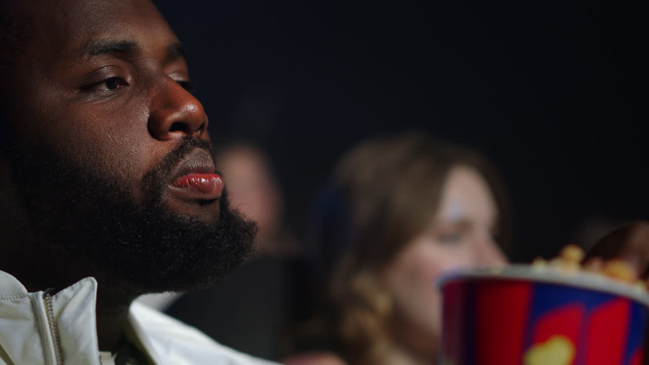 Afro guy looking film in cinema