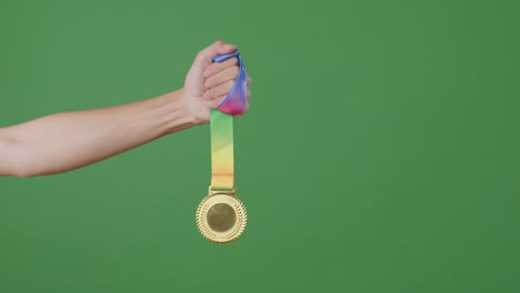 hand holding a gold medal