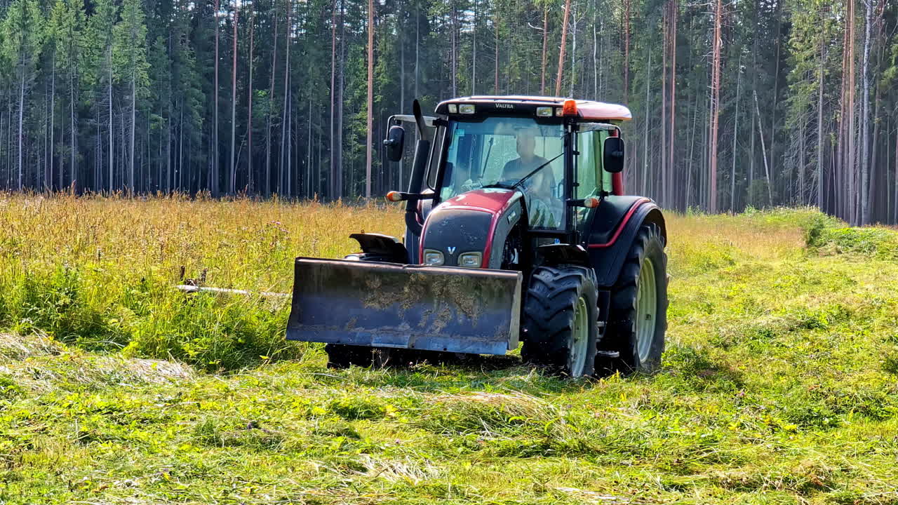 Slow motion shot of worker farming with tractor vehicle in the Woods at daylight