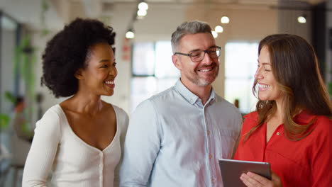 Portrait-Of-Multi-Cultural-Business-Team-With-Digital-Tablet-Meeting-In-Modern-Open-Plan-Office