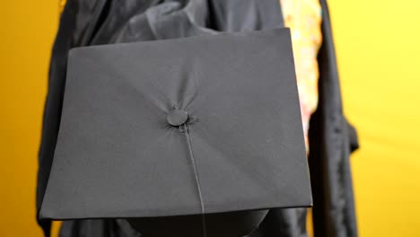 student hold hats in hand during commencement success