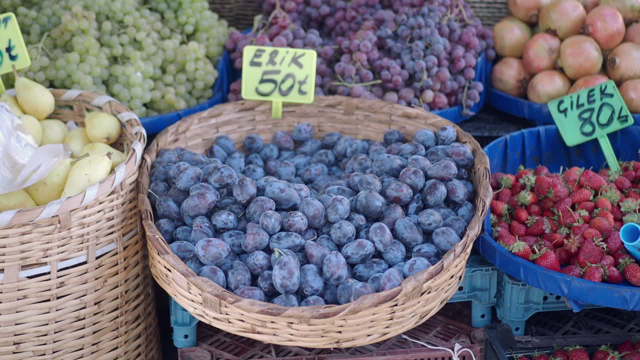 Fruit stand with grapes, strawberries, plums, and pears