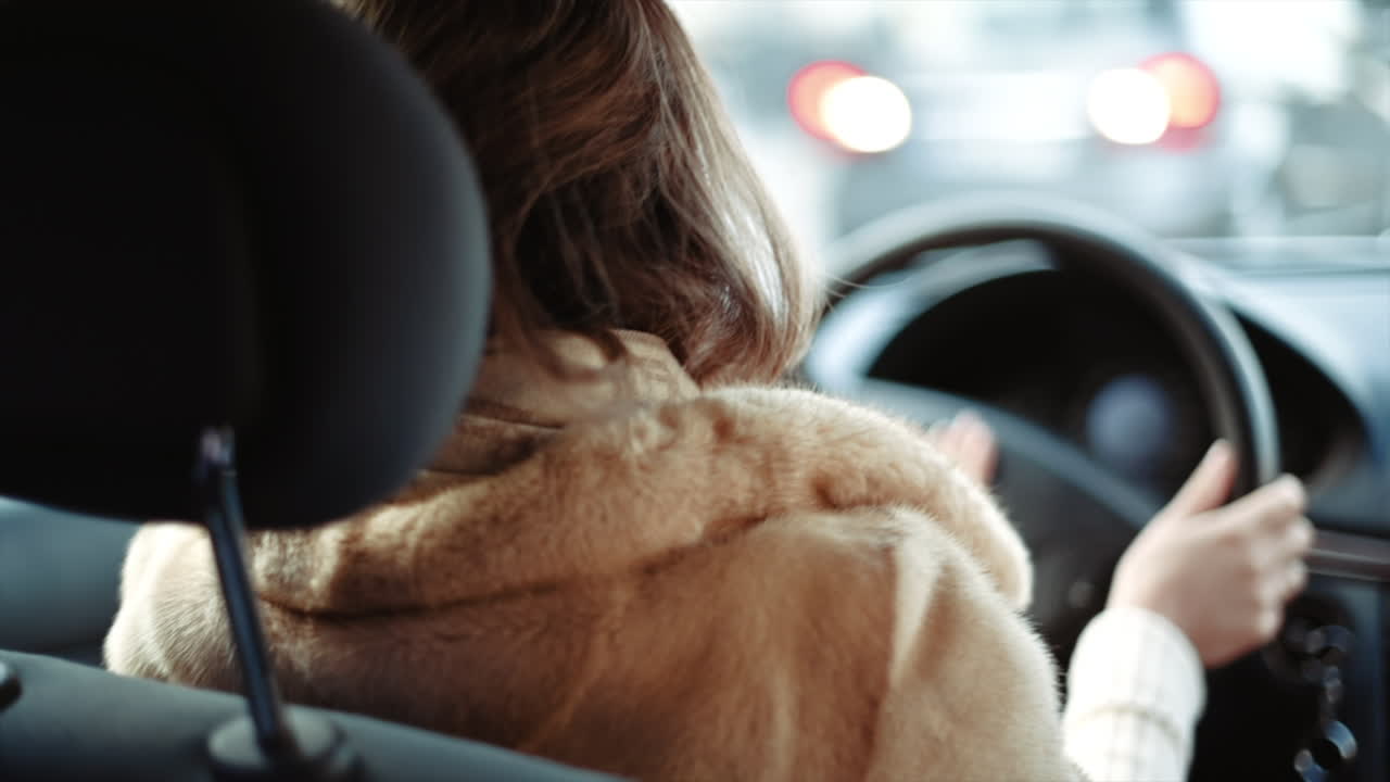 Woman driving a car in slow motion, hands on wheel