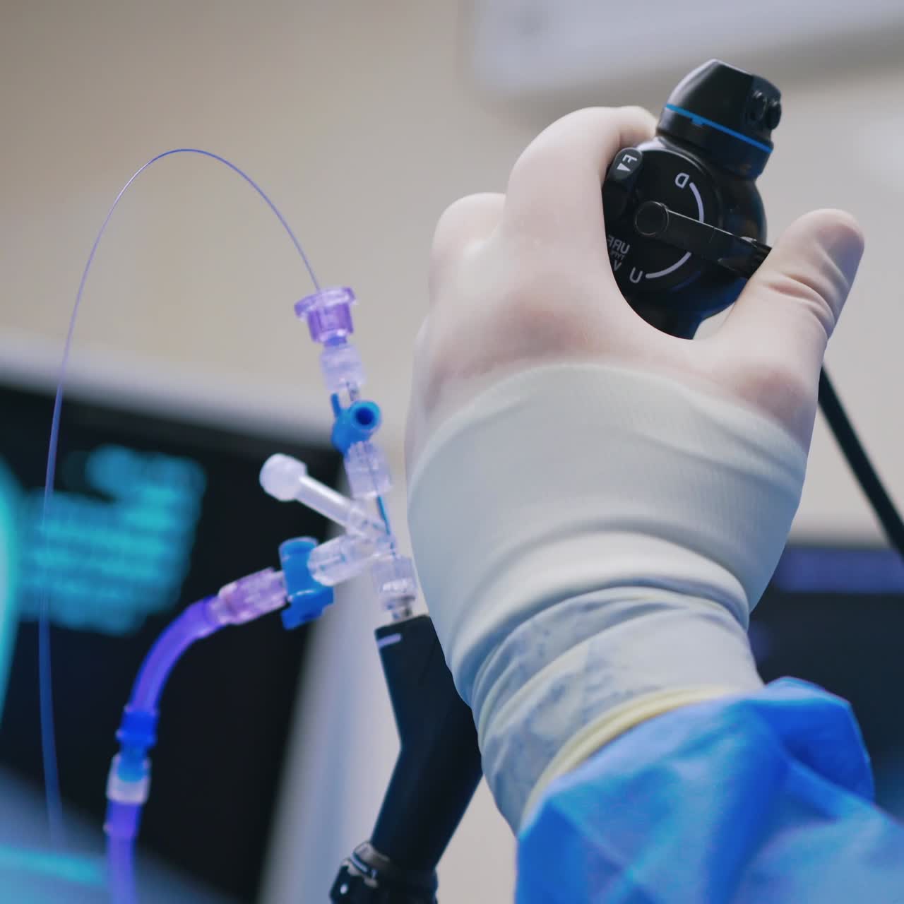 Endoscopic surgery. Surgeon's hand holds medical instrument on the blur background of a monitor. Close-up.