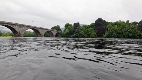 river flowing under historic stone bridge in dunkeld