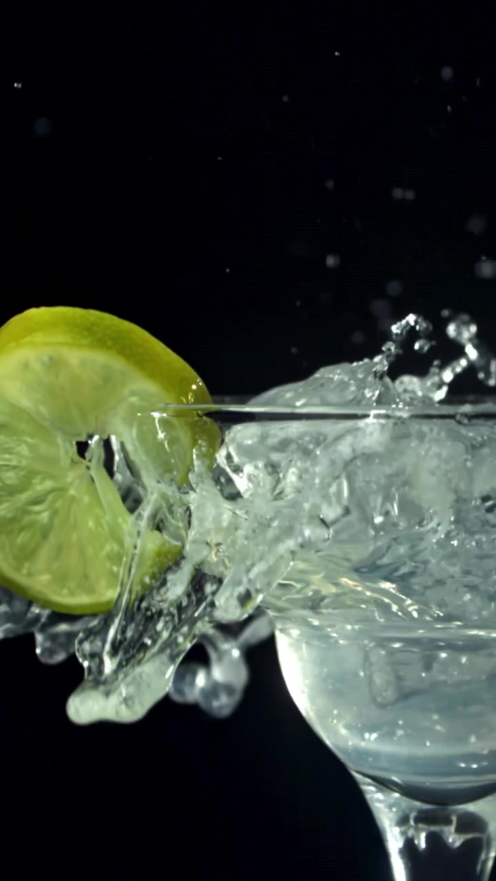 Cubetto di ghiaccio che cade in un cocktail Margarita con lime e bordo di sale