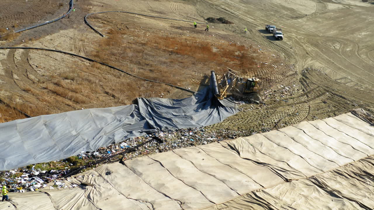 Aerial View of Landfill Operations with Heavy Machinery and Workers