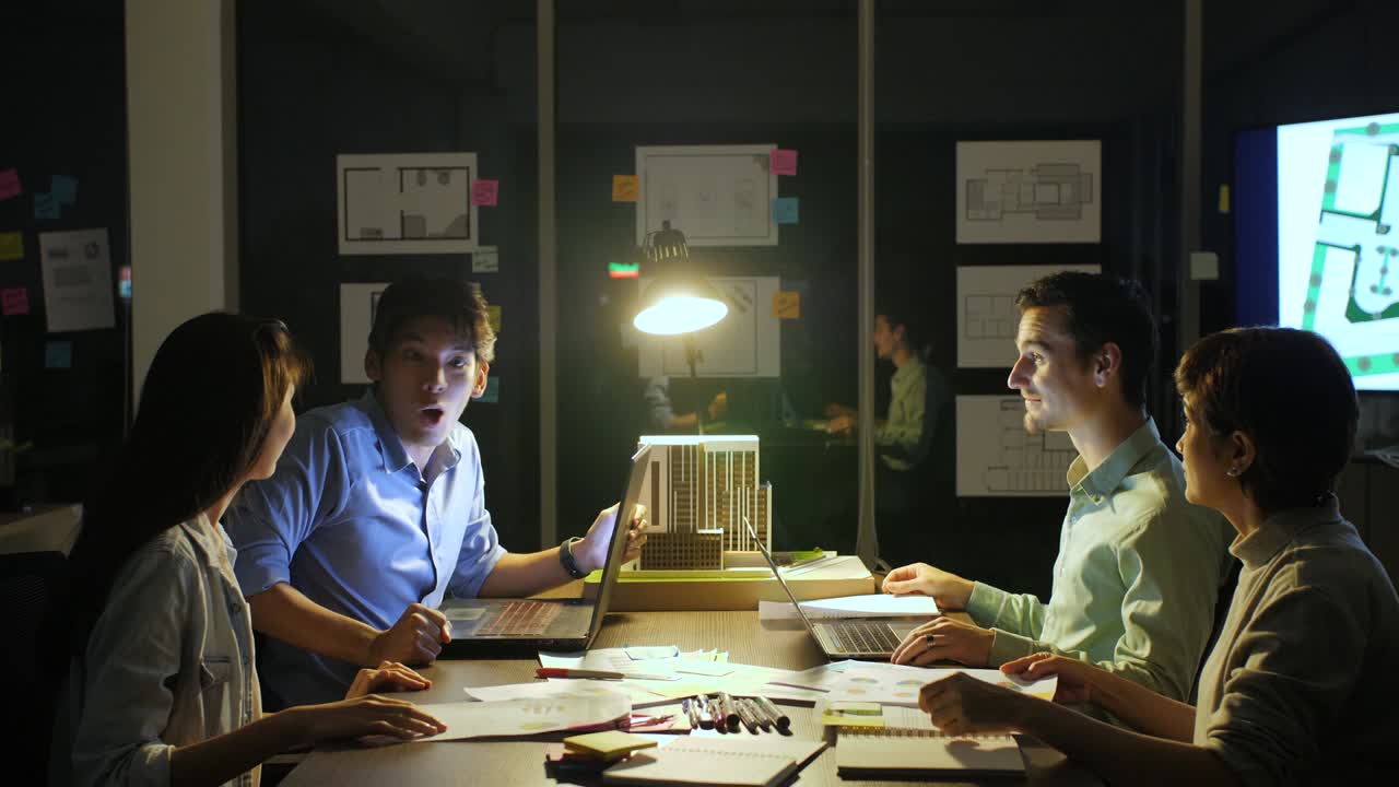 joven equipo creativo y líder de equipo maduro dando alto cinco el uno al otro después de una exitosa reunión de negocios en la sala de reuniones por la noche