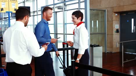 female airport staff checking passport of commuters