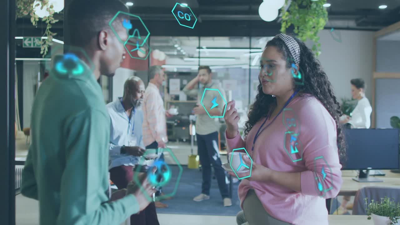 Man checking phone and gesturing, woman holding cup bonding, causing teal icons over office