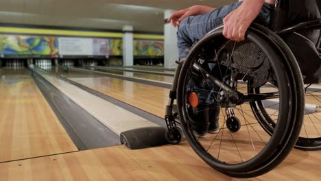 two young disabled men in wheelchairs playing bowling in the club