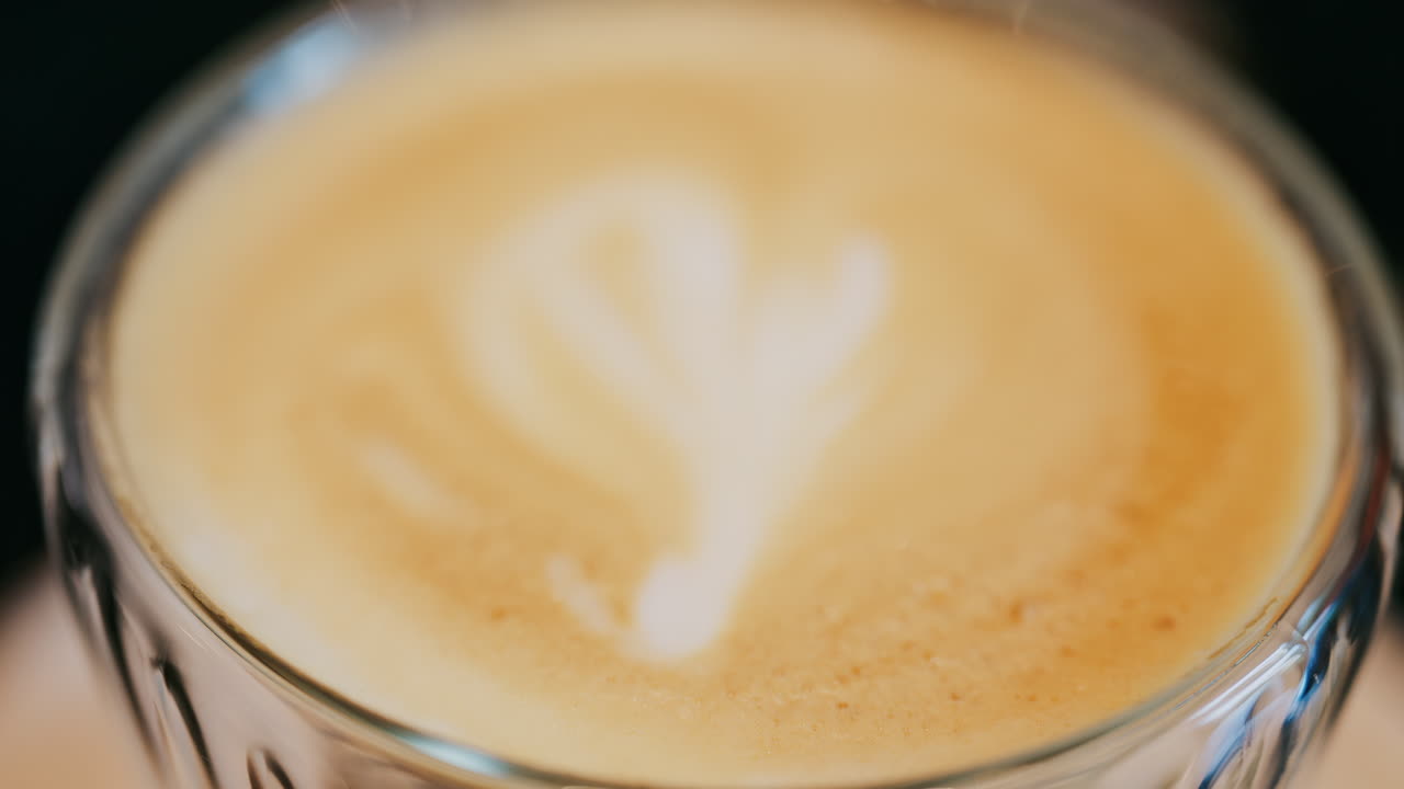 Close up of a glass cup with a latte at a cafe
