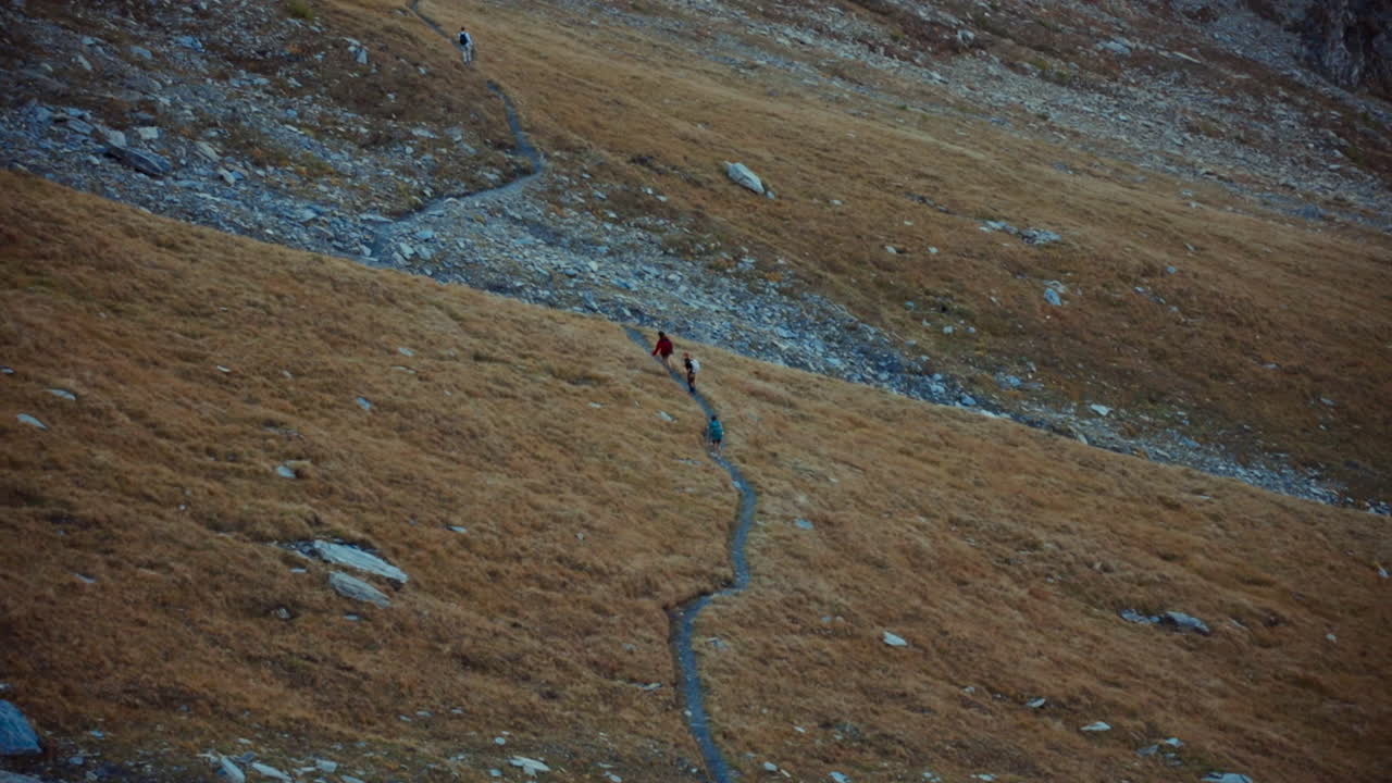 Tourists Hikers Walking Along Mountainous Trail in Italian Alps Region in Autumn Season