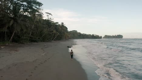 man walking at sandy beach as the waves coming on the shore