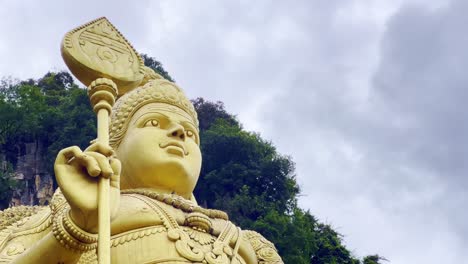 low angle shot of close up of a golden statue of hindu god murugan outside of subramanya temple along batu caves, malaysia