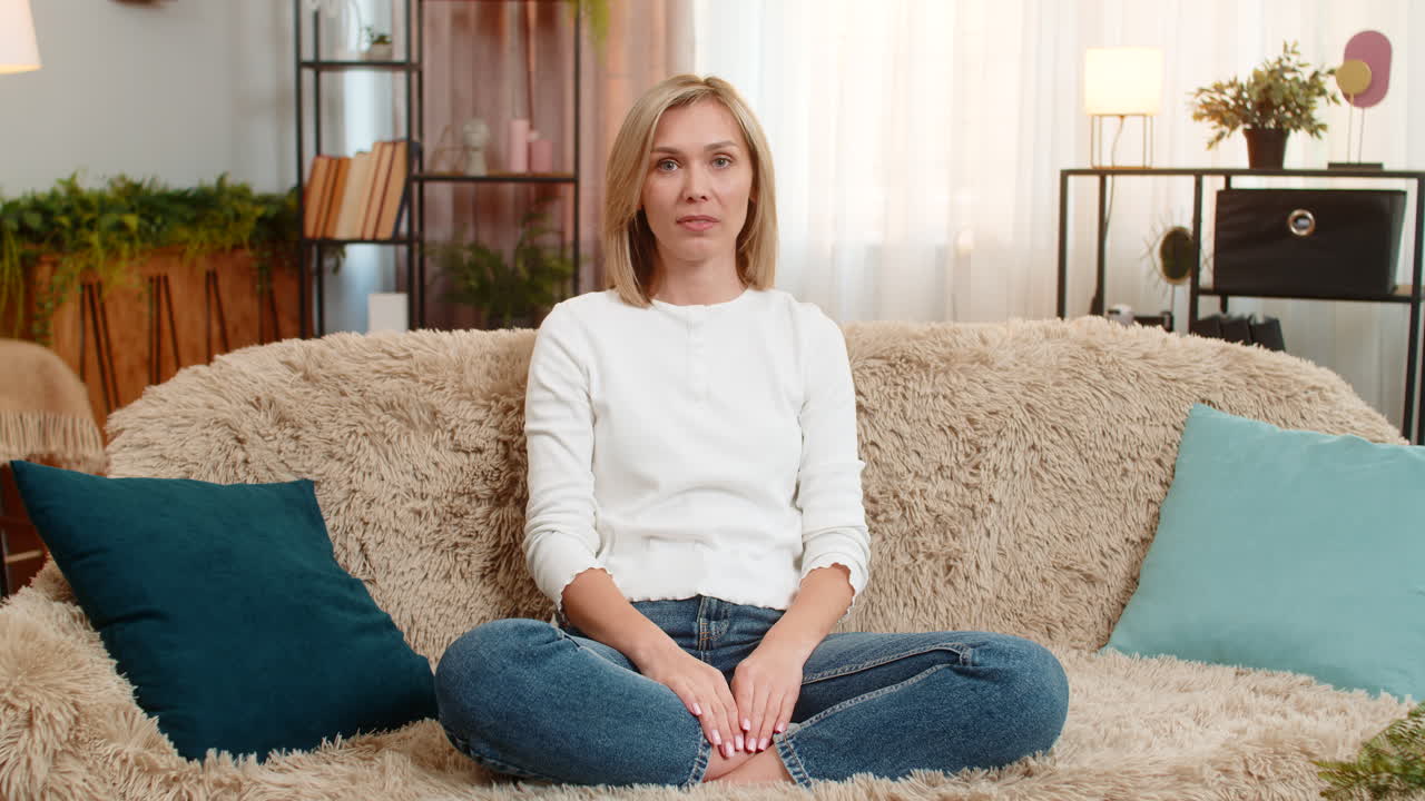 Adult woman celebrating success at home showing fist pump in air joy strong emotional expression