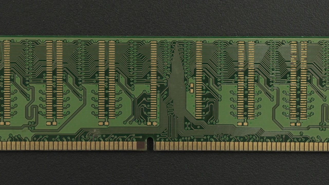 A close examination of a green RAM circuit board showcasing intricate gold connectors and patterns. Ideal for technology presentations or educational content.