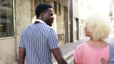 a diverse couple strolls down city street