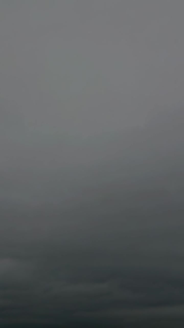 Vertical video: Recording camera capturing dense gray cloud layer overhead for weather observation