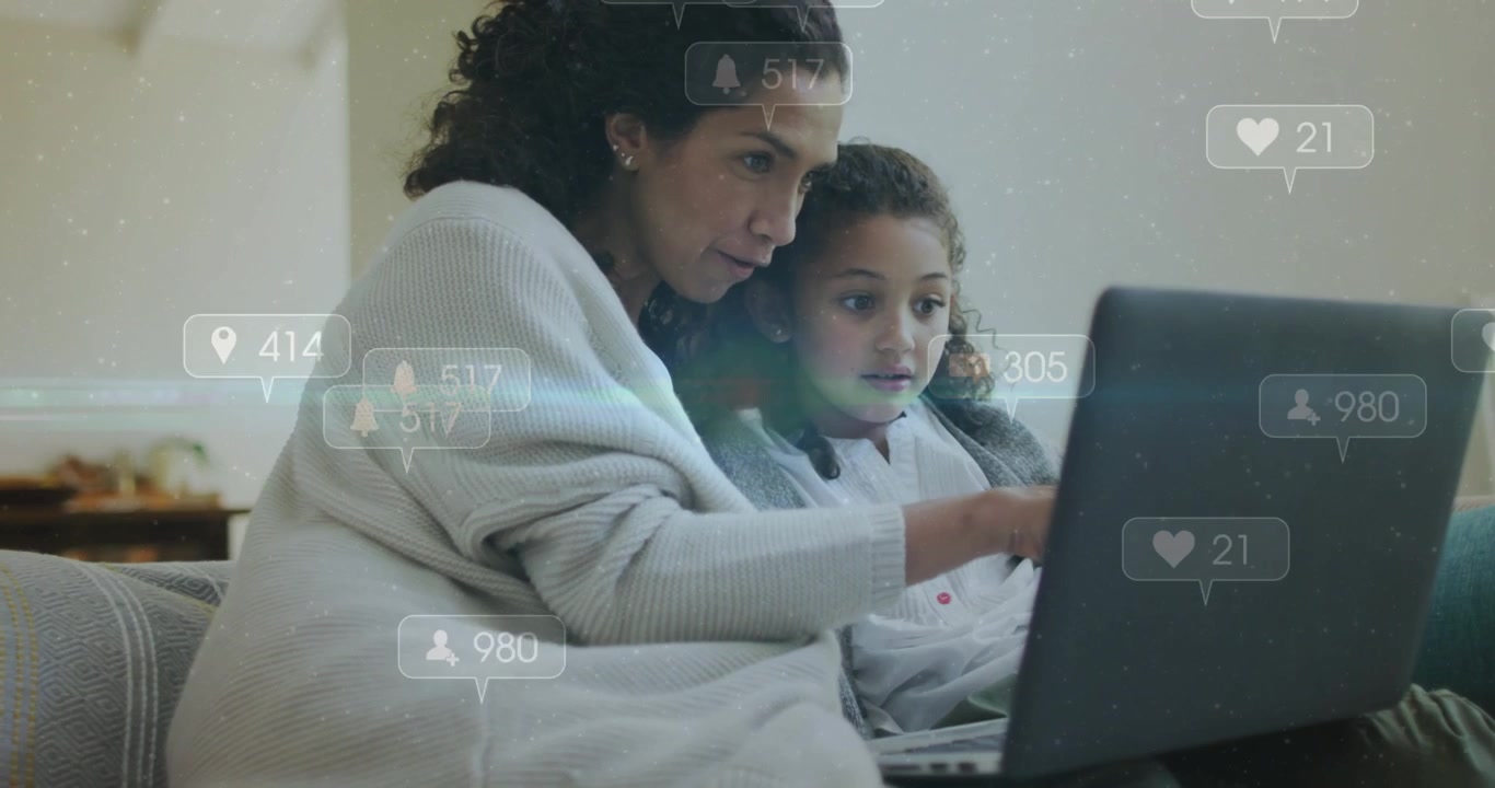 Madre señalando el portátil y guiando a su hija, con 'me gusta' animados apareciendo a su alrededor, enseñando redes sociales.