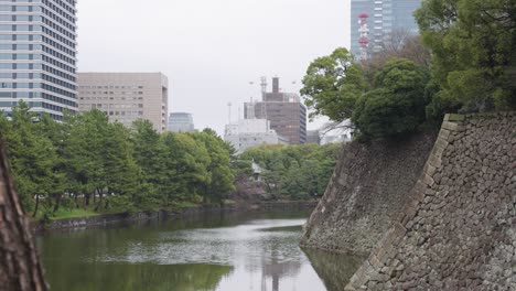 cloudy day in tokyo japan, pan over city and moat wall