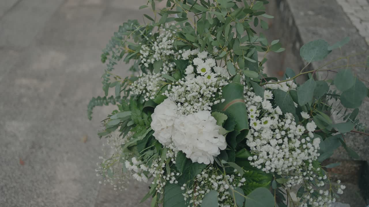 Primer plano cenital de un ramo de novia floral blanco con hojas verdes