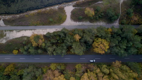 vista de arriba hacia abajo de un vehículo en una carretera paralela a un sendero para caminantes y árboles de otoño