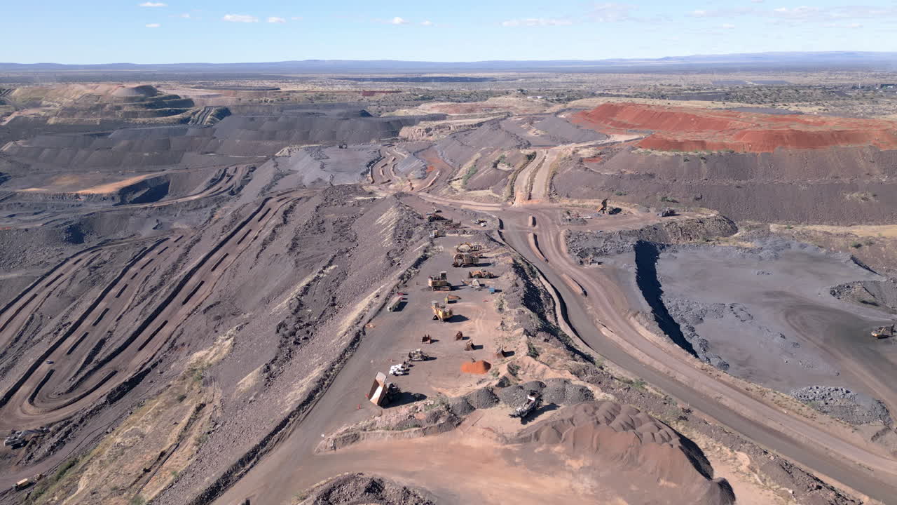 Aerial of an opencast manganese mine with waste dumps and vehicles