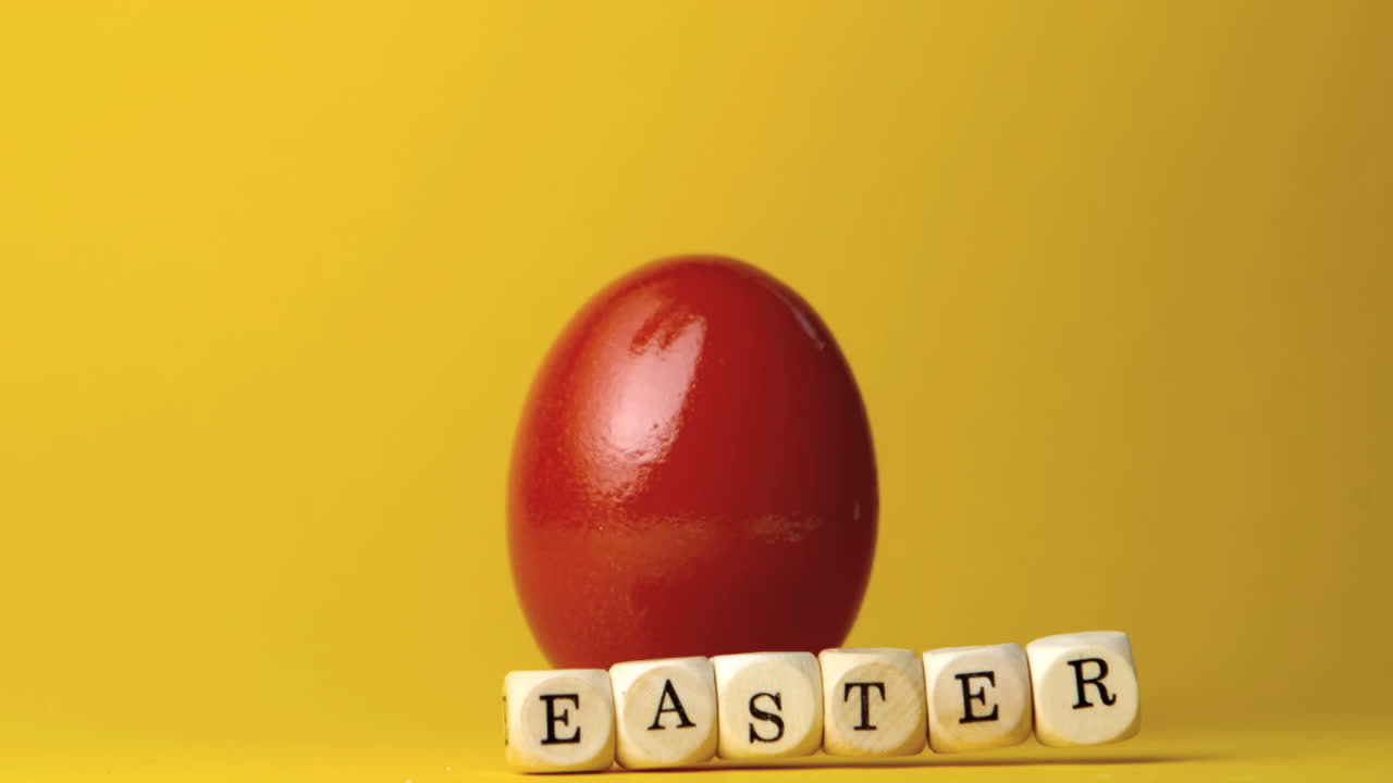 Dadi che compongono la parola Pasqua cadendo davanti a un uovo rosso