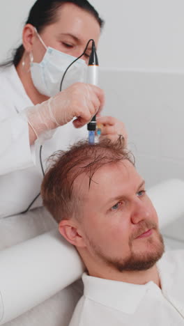 trichologist doing man improve hair growth procedure dermapen microneedling vitamin injections