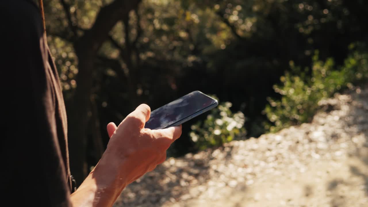 persona que utiliza un teléfono inteligente al aire libre