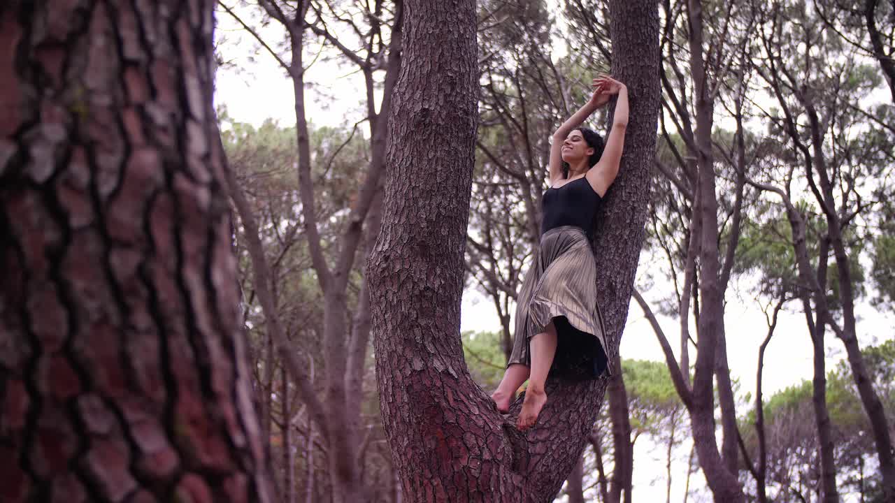 The Woman in Black Dress Reaching Her Feet From The Back On Top Of The Tree