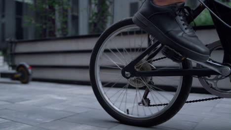 closeup male legs pedaling riding shared bicycle. modern city transportation.