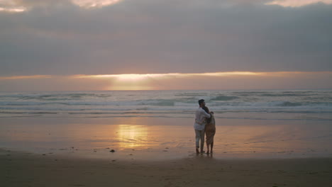 Pareja-Amorosa-Cruzando-La-Costa-Al-Atardecer-En-Verano.-Pareja-Abrazada-En-El-Mar-Verticalmente